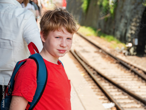 Portrait of an Adventurous 11-Year-Old Boy with Backpack Enjoying Summer Break at Regional Station in Germany photo