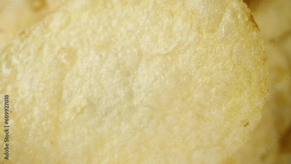 Imitation of a fall, concept. A single potato chip falls down towards the rest, captured in macro. Imitation of a fall, concept. A single potato chip falls down towards the rest, captured in macro.