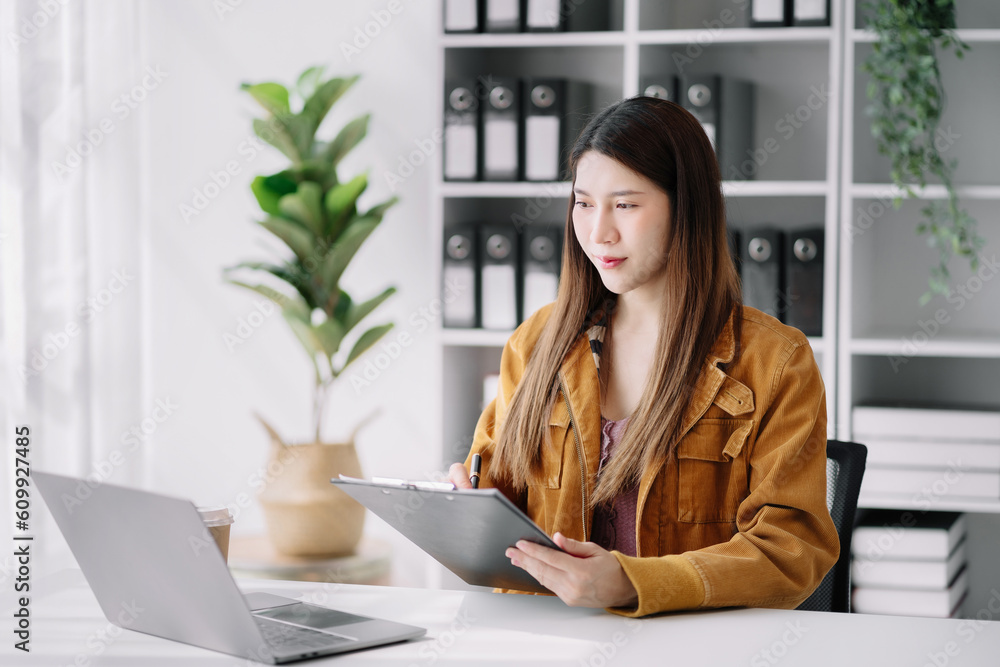 Female working at office with laptop and documents on his desk, financial adviser analyzing data. Female working at office with laptop and documents on his desk, financial adviser analyzing data.
