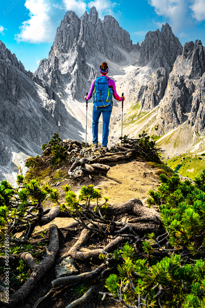 Athletic woman enjoys view on Cadini group from epic view point in the morning. Tre Cime, Dolomites, South Tirol, Italy, Europe. Athletic woman enjoys view on Cadini group from epic view point in the morning. Tre Cime, Dolomites, South Tirol, Italy, Europe.