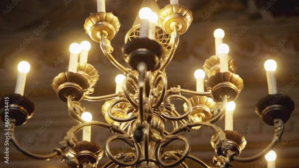 Golden luxury chandelier in the temple. Golden luxury chandelier in the church. The ceiling in church is painted with icons on dome. Christian or Catholic Church. Religion, faith in God. Prayers.