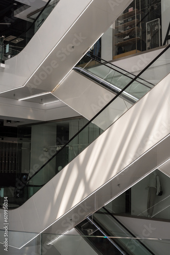 Modern glass elevator and escalator in a shopping mall. Empty mall.