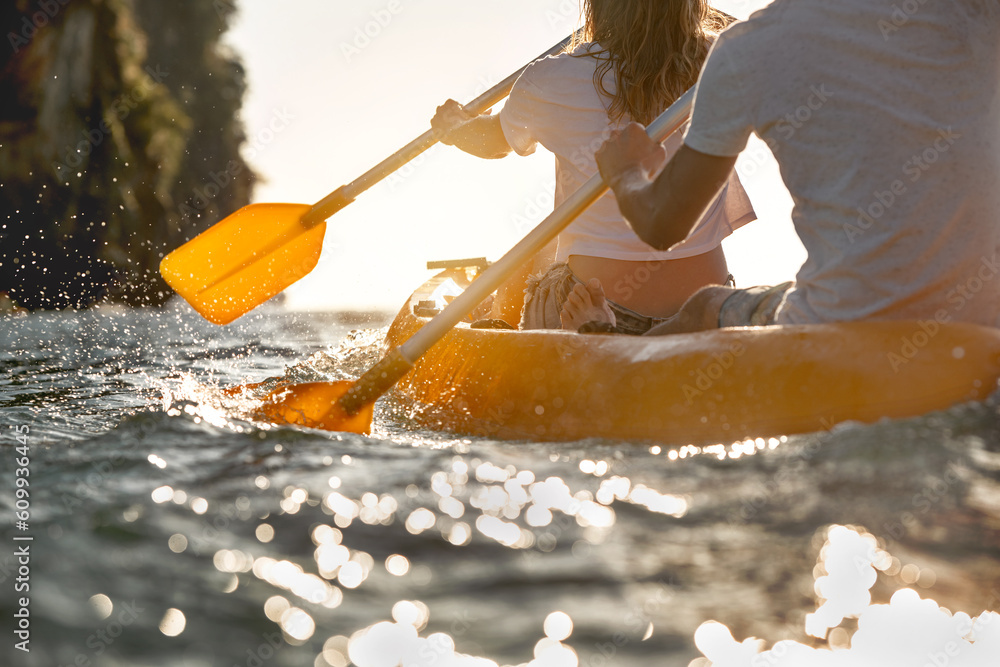 Close up photo of kayaking couple at sunset sea - obrazy, fototapety, plakaty 
