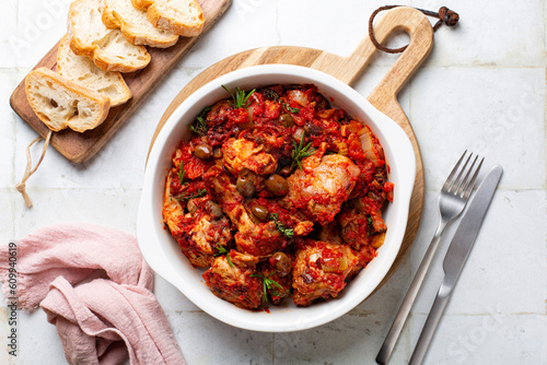 Italian rabbit stew cooked with white wine, tomatoes and olives, thyme and rosemary. Coniglio all'ischitana. Ischia dish. Top view.