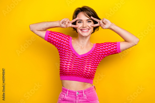 Portrait of adorable gorgeous lady wear stylish clothes hand near face v-sign enjoy holiday weekend isolated on yellow color background