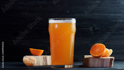 fruit beer with tangerines on a wooden table. craft beer