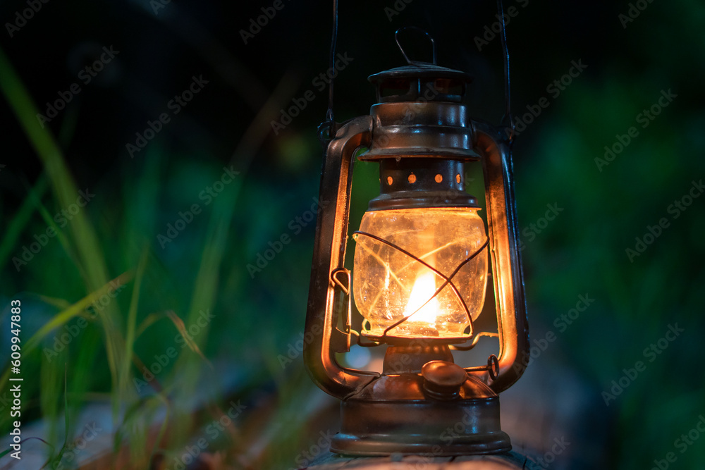 antique oil lamp on the old wooden floor in the forest at night camping atmosphere