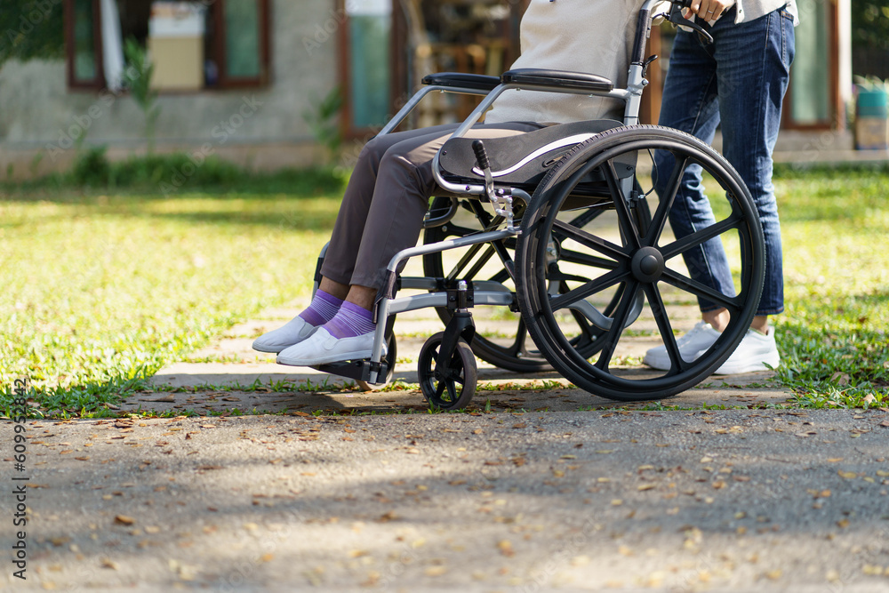 Obraz premium Nursing home. Young caregiver helping senior woman in wheelchair.