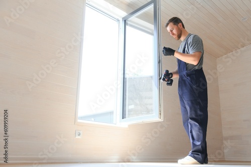 The worker installing and checking window in the house. Concept of new modular houses.