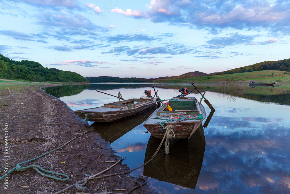 Obraz premium Small iron boat docked by the water