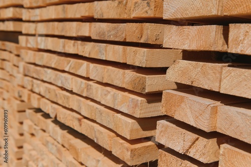 Stack of lumber of a wooden board from a tree, close-up, background. Wooden boards at the sawmill, carpentry workshop. Sawing and air drying of wood. Woodworking industry. Wooden boards