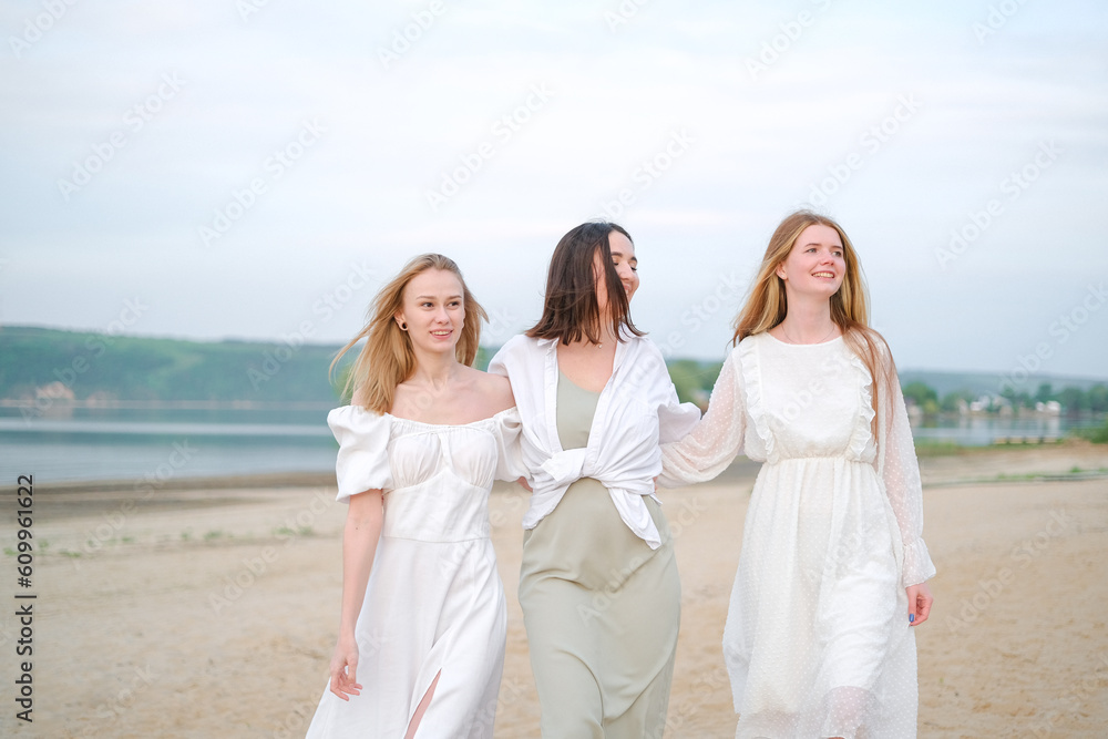Three beautiful girls are walking on the beach greeting the summer sunrise. It's vacation time, laughter and smiles. Three beautiful girls are walking on the beach greeting the summer sunrise. It's vacation time, laughter and smiles.