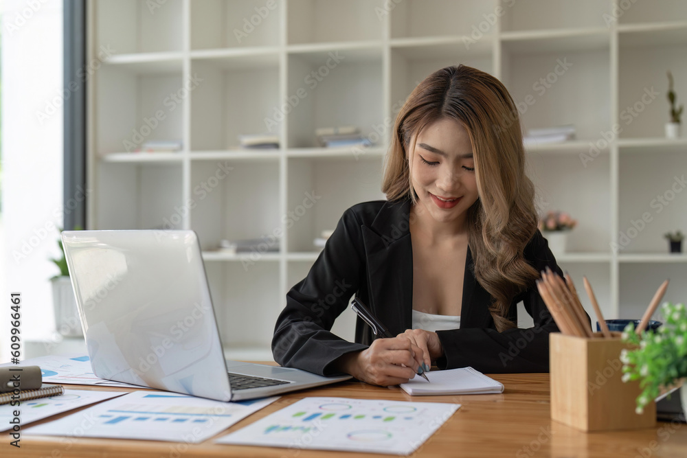 Business woman hand working at a computer and writing on a notepad. business financial concept Business woman hand working at a computer and writing on a notepad. business financial concept