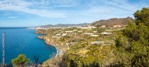 View on Maro beach and Nerja in the back, located on the coastline of the Costa del Sol in Southern Spain; plastic greenhouses dotted all over the area