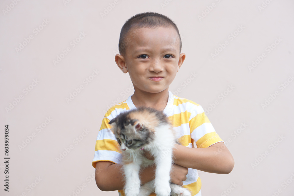 Obraz premium Asian boy smiling happily with his pet cat
