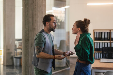 Colleagues arguing in office, problems at work.