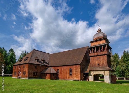 Wooden evangelical articular church of the Svaty Kriz (Holy Cross), is one of the largest wooden churches in Europe.Green meadow, blue sky white clouds, old architecture. Paludza, Svaty Kriz.