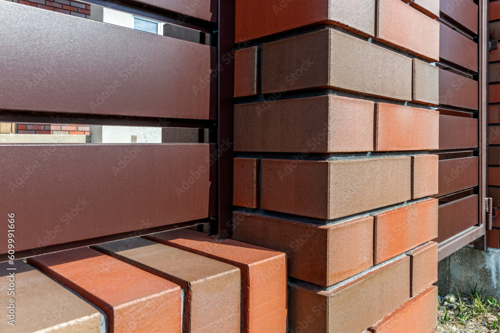 Fragment of a modern fence lined with decorative bricks in the old style Fragment of a modern fence lined with decorative bricks in the old style