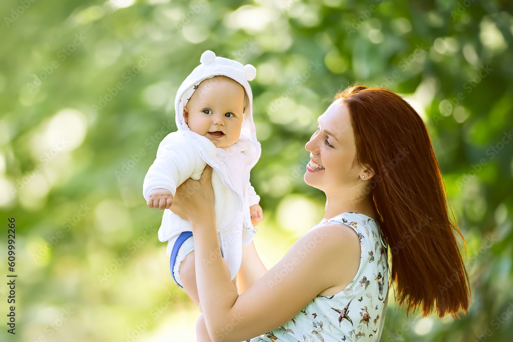 happy harmonious family in park. mother hold and throws up the baby boy