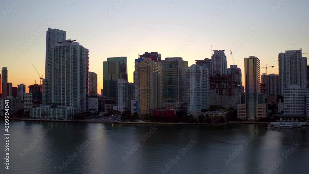Aerial Shot Of Modern Buildings By Sea Against Sky, Drone Ascending Forward Over City At Sunset - Miami, Florida Aerial Shot Of Modern Buildings By Sea Against Sky, Drone Ascending Forward Over City At Sunset - Miami, Florida