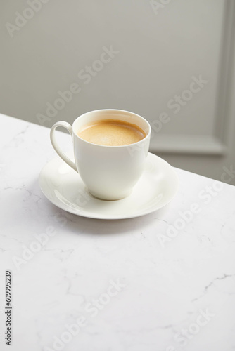 Cup of coffee, on white marble table
