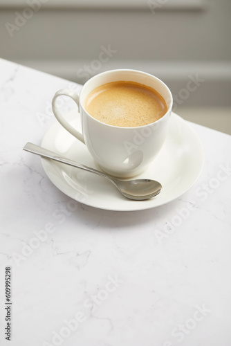 Cup of coffee, on white marble table