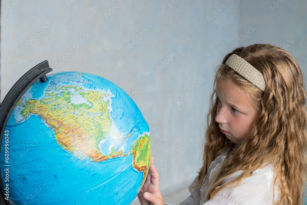 primary schoolgirl looking at globe. geography interesting learning.concept of save the world and learn through play activity for kid education at home.lovely girl in classroom primary schoolgirl looking at globe. geography interesting learning.concept of save the world and learn through play activity for kid education at home.lovely girl in classroom