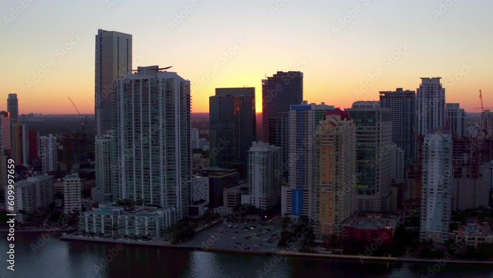 Aerial Shot Of Modern Buildings In City By Sea Against Sky, Drone Flying Backward Over Coastline At Sunset - Miami, Florida Aerial Shot Of Modern Buildings In City By Sea Against Sky, Drone Flying Backward Over Coastline At Sunset - Miami, Florida