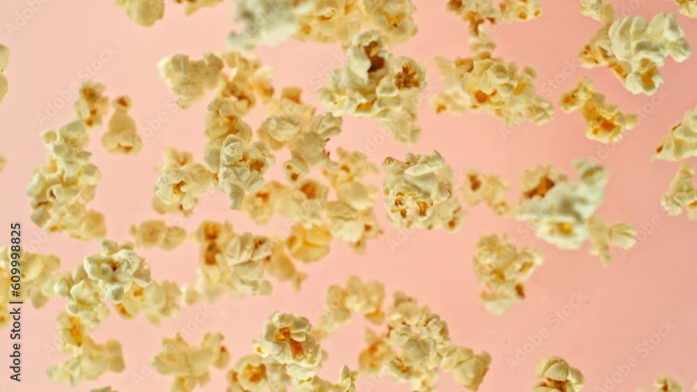 Super slow motion of rotating popcorn in the air. Isolated on colored background. Filmed on high speed cinema camera, 1000fps, placed on high speed cine bot, following the target. Speed ramp effect.
