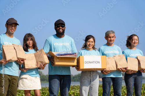 group of diverse volunteer carrying donation box raising money charitable working together for campaign sharing to help underprivileged people by donate food, clothing, support education environment