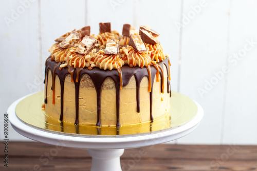 Foto Gorgeous snickers cake with peanut butter cream, melted chocolate, candy bars an
