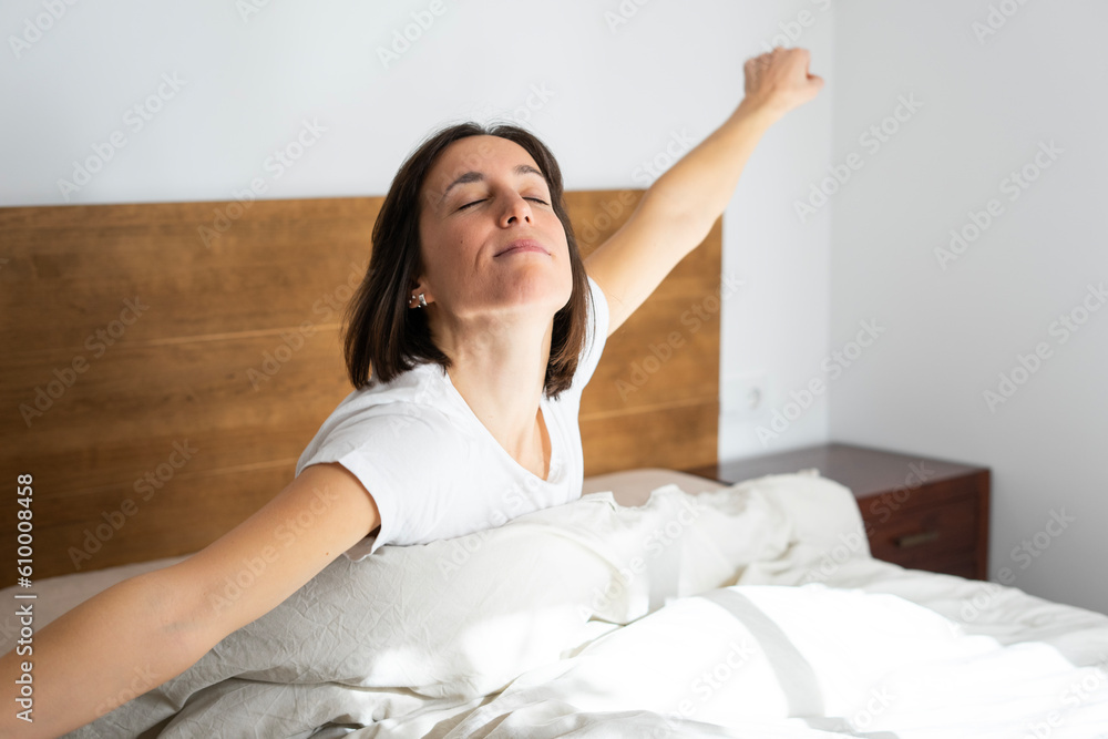 Girl in her double bed, waking up with a yawn Girl in her double bed, waking up with a yawn