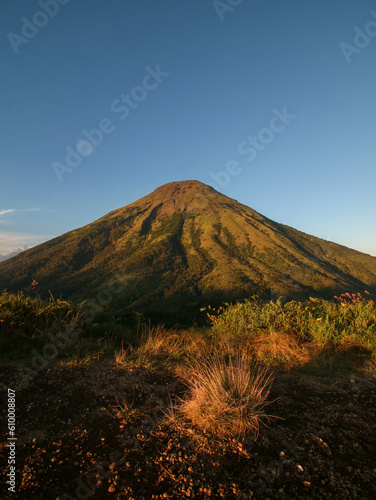 Portrait of sindoro mountain from top of mount kembang during sunset 