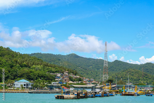 Panoramic view of harbor or port with communication or provider tower and village on hillside. Merak port in Banten, Indonesia.