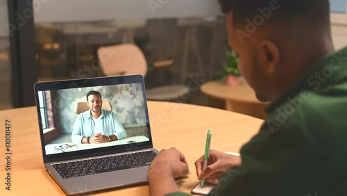 Two indian male office employee talking online via video connect on the laptop, business partners discussing tasks, men colleagues involved in video meeting on the distance. Video call concept