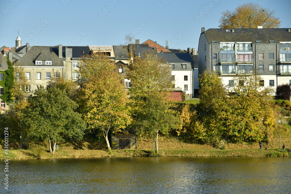 Les façades arrières des immeubles dominant la végétation luxuriante du parc longeant le lac des Doyards à Vielsalm