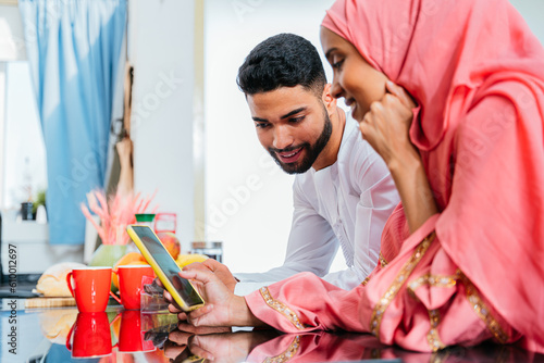 Canvas Print happy middle-eastern married couple spending time together at home and wearing t