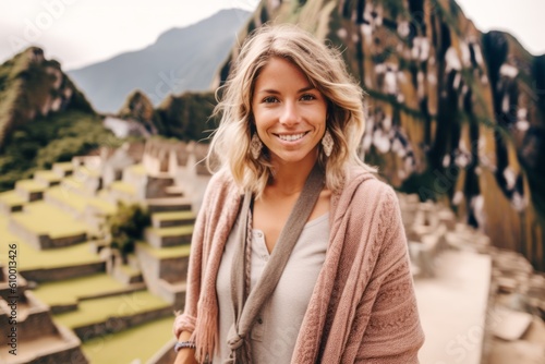 Portrait of a beautiful young woman on the background of the ancient city of Machu Picchu. © Anne Schaum