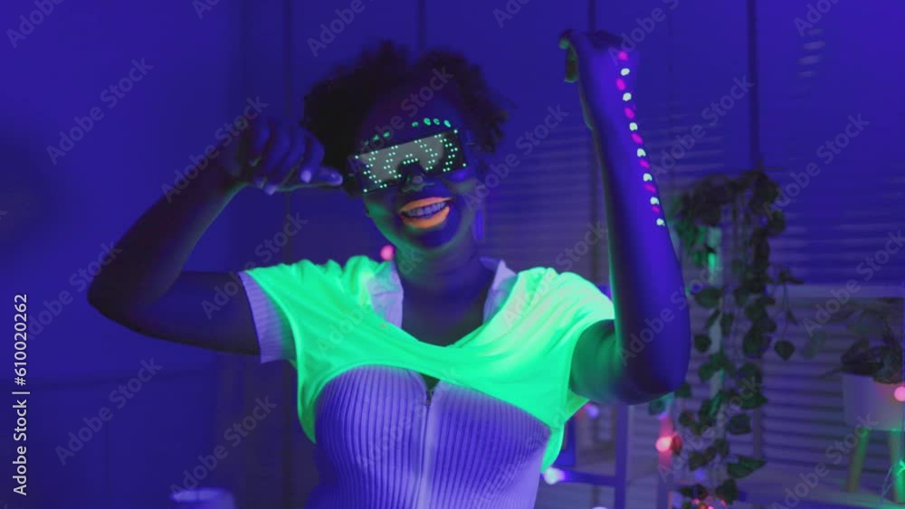 Neon asian woman dancing. Fashion model woman in neon light, portrait of beautiful model with fluorescent make-up, Art and future design of female disco dancer posing in UV, colorful make up. Neon asian woman dancing. Fashion model woman in neon light, portrait of beautiful model with fluorescent make-up, Art and future design of female disco dancer posing in UV, colorful make up.