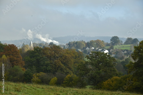 Fum  e blanche d une usine montant dans la brume au dessus d un paysage bucolique de collines bois  es    Vielsalm