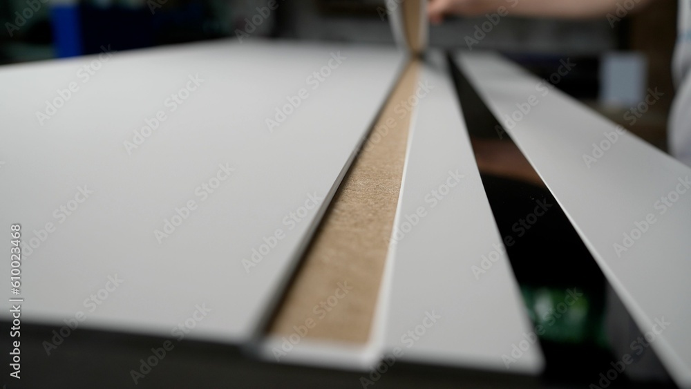Bonding wooden planks and figured glass for doors with silicone. Furniture production, wood and MDF panels. The master glues a strip of glass on the door. Door production. Bonding wooden planks and figured glass for doors with silicone. Furniture production, wood and MDF panels. The master glues a strip of glass on the door. Door production.
