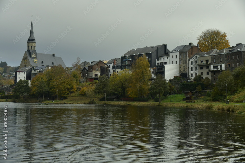 Le village de Vielsalm avec l'église paroissiale Saint Gengoux le long des berges du lac des Doyards sous une chape de brume automnale