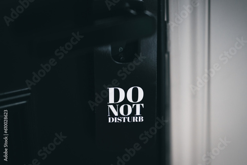 Black do not disturb sign on a black hotel room door