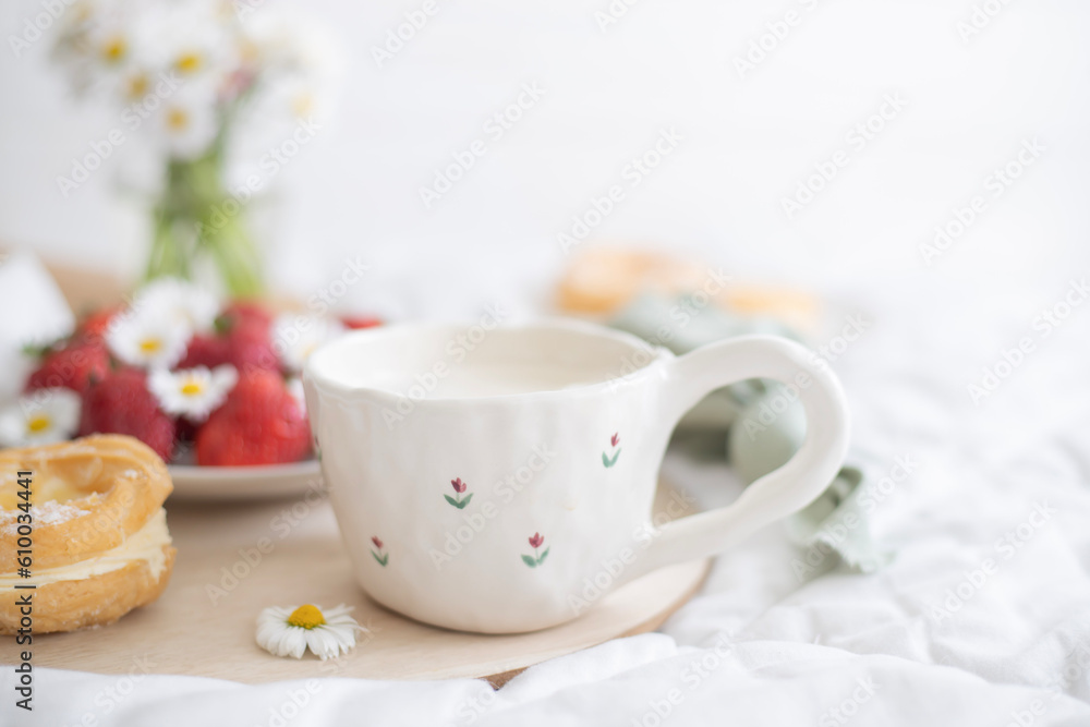 A plate of strawberries is decorated with white daisies. Berries with vitamins and a cup of aromatic coffee A plate of strawberries is decorated with white daisies. Berries with vitamins and a cup of aromatic coffee