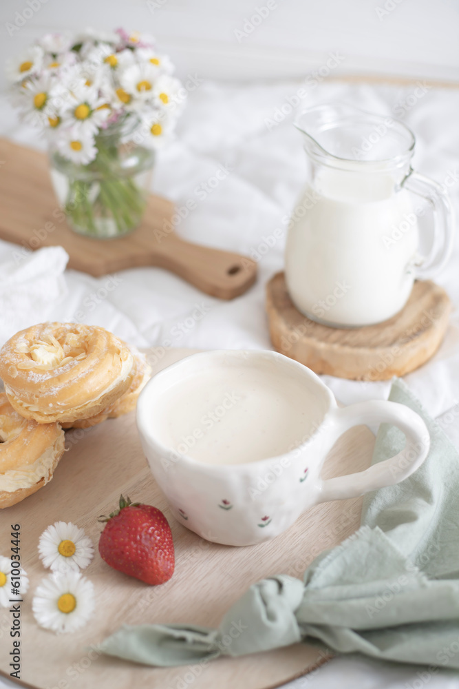 A cup of coffee and dessert with cream for breakfast. Morning in bed A cup of coffee and dessert with cream for breakfast. Morning in bed