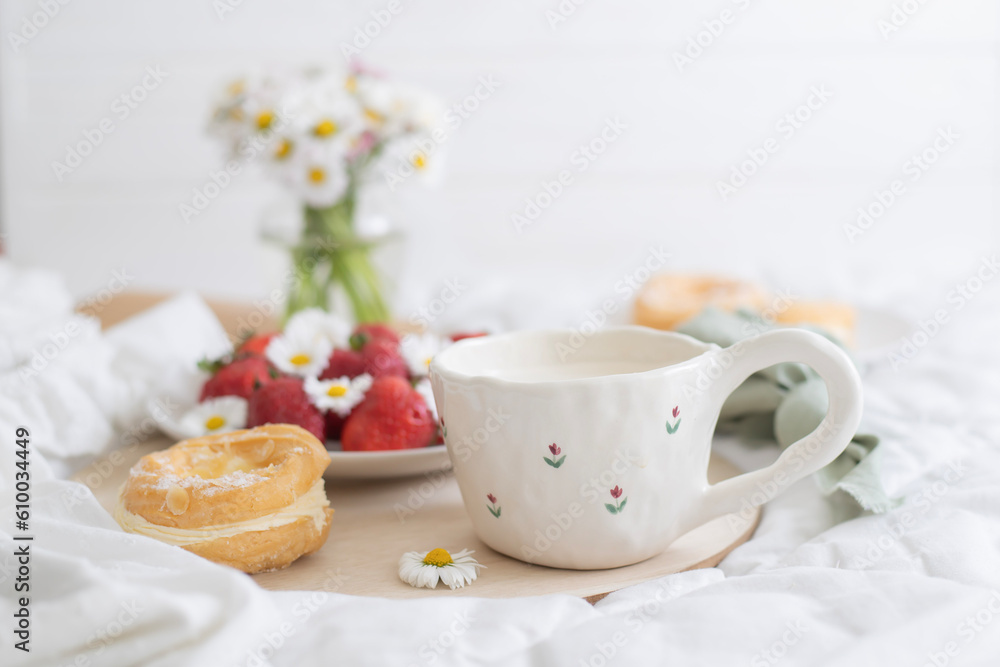 A plate of strawberries is decorated with white daisies. Berries with vitamins and a cup of aromatic coffee A plate of strawberries is decorated with white daisies. Berries with vitamins and a cup of aromatic coffee