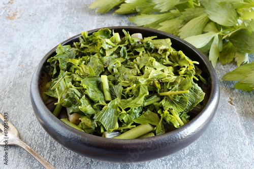 Boiled lovage herb in a bowl. Cooked fresh organic green vegetables. photo