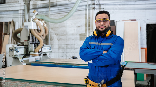 Portrait of carpenter worker doing his job in workshop. Technician handcrafted furniture in furniture factory. .