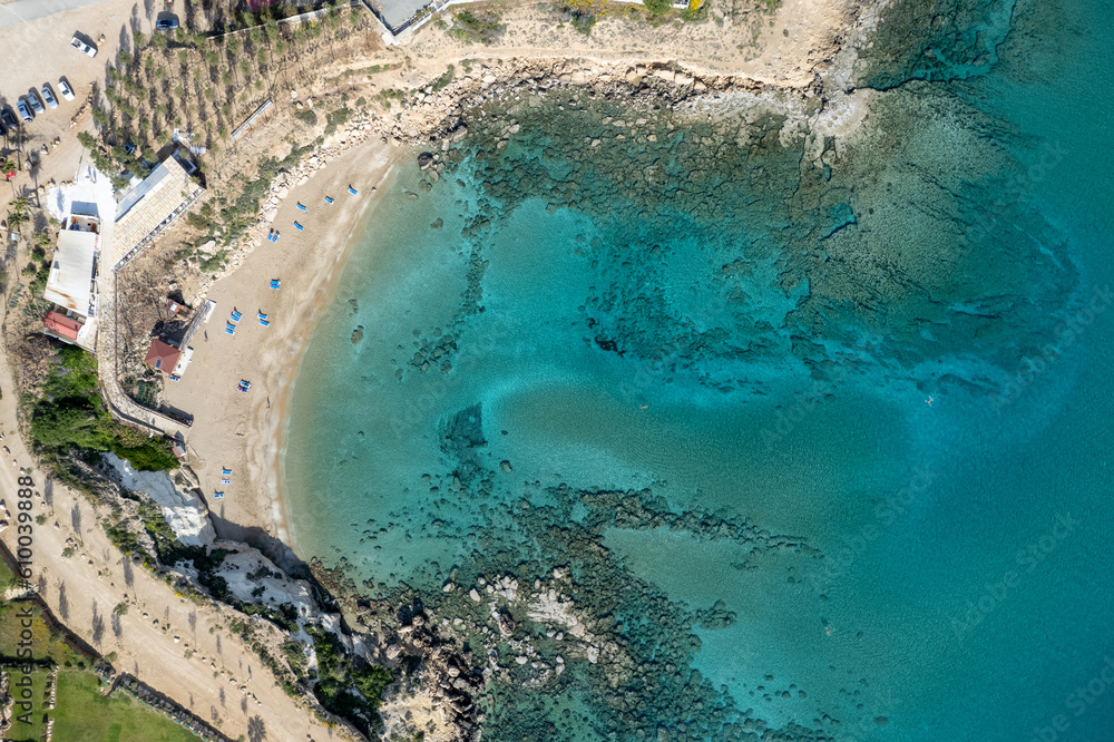 Drone aerial of beach umbrellas and people swimming in the sea. Summer holidays in the sea.