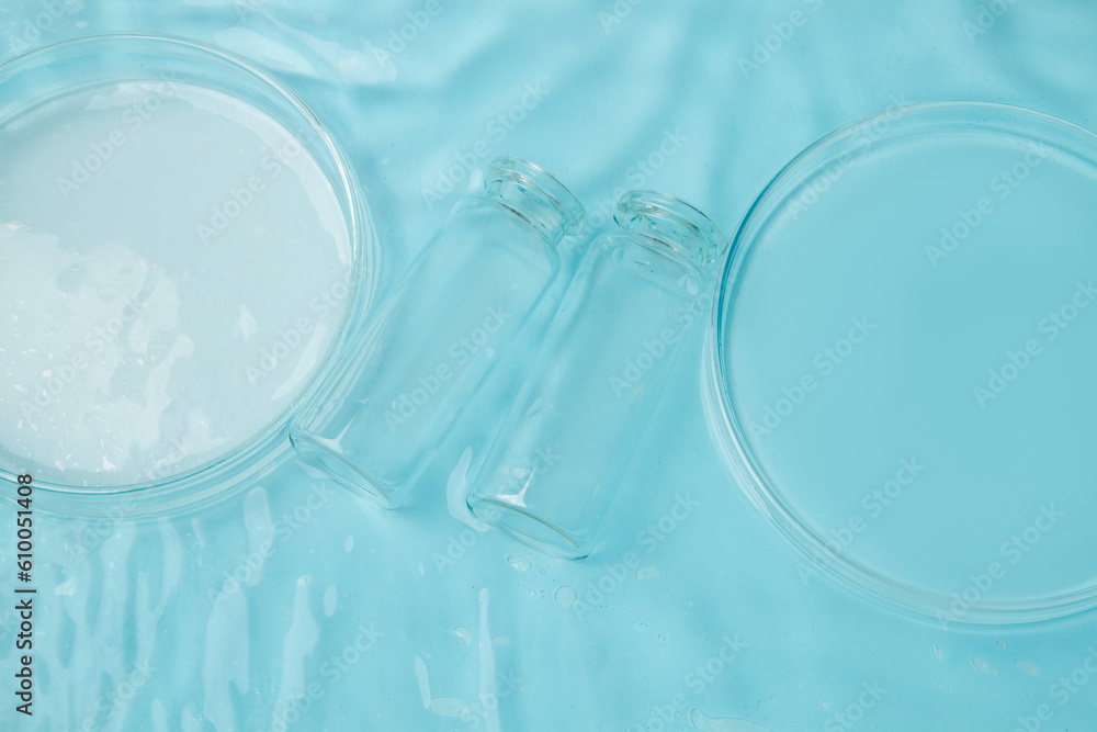 Set of laboratory utensils empty Petri dish, flasks, jars on the background of blue water Set of laboratory utensils empty Petri dish, flasks, jars on the background of blue water